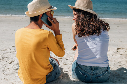 wedding couple with mobile phone on the beach