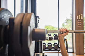 female fitness trainer and determined woman raising dumbbells working out at a gym. Exercise, fitness and healthy lifestyle.