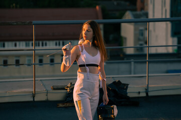 Two fencers woman practice on a rooftop with the city in the background.