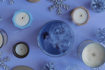 Candles on blue background, top view. Christmas and winter season concept. Smoldering candle - 634573108