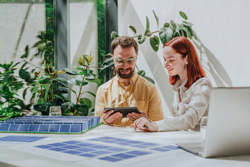 Smiling business colleagues using tablet PC at desk in office
