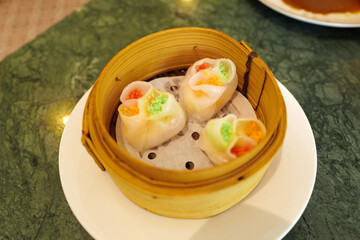 Chinese Dim Sum, steamed pork and seafood dumplings served in wooden basket container