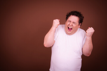 Funny fat man posing on a brown background.