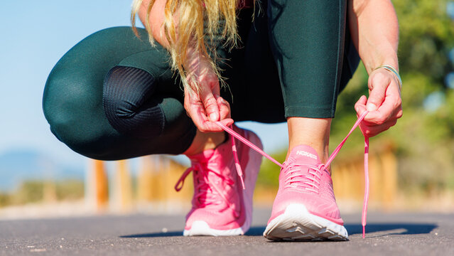 France, July 2023- HOKA running shoe, woman tying laces