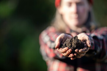 regenerative organic female farmer, taking soil samples and looking at plant growth in a farm....