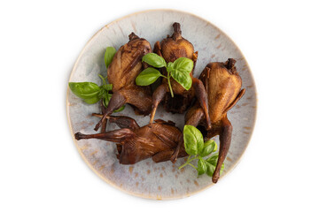 Smoked quails on a ceramic plate isolated on white background. Top view