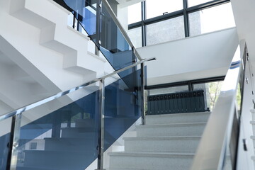 interior of a modern building, stairs and glass balustrade - obrazy, fototapety, plakaty