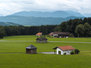 Fototapeta na wymiar Voralpen bei Irschenberg. Hütten im Vordergrund