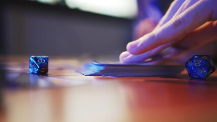 A man drawing trading card game from a deck on a table