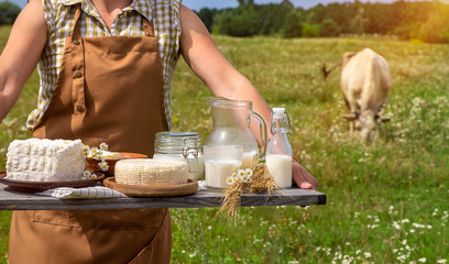 Dairy products on a cow farm are held by a woman in her hands. Selective focus.