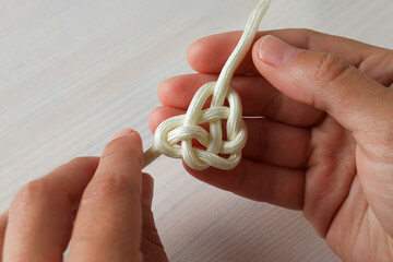 Celtic knot in the shape of a heart made of white cord. Concept of creative unity, faith and...