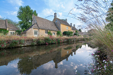 Fototapeta na wymiar Lower Slaughter village, Cotswolds Gloucestershire. Cotswolds houses with reflection in the river. England, United Kingdom, Europe. 