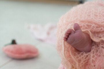 The sole of a newborn's foot emerging from a woolen blanket
