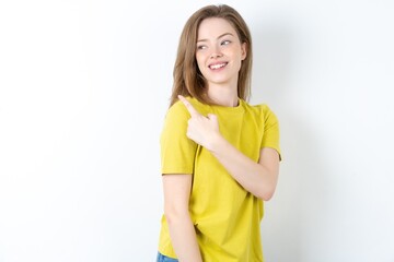 Young beautiful girl wearing yellow T-shirt glad cheery demonstrating copy space look novelty