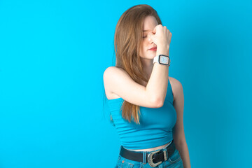 Sad Young beautiful girl wearing blue T-shirt suffering from headache holding hand on her face