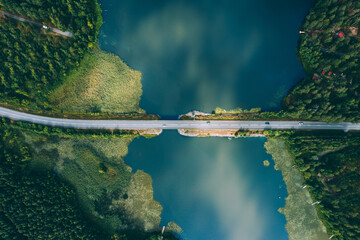 Aerial view of bridge asphalt road with cars and blue water lake and green woods in Finland. - obrazy, fototapety, plakaty