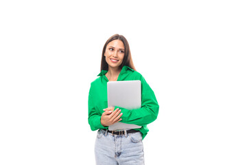 well-groomed brunette long-haired young business woman in a green shirt works in the IT sphere on a white background with copy space