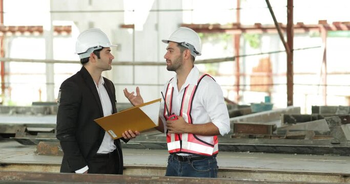building and construction worker, Hiapanic latin male wearing safety hard hat helmet standing at Prefabricated concrete walls Industry Manufacturing Factory. Unity and teamwork