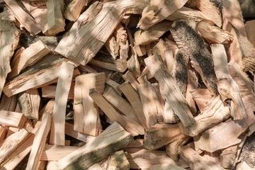 Fotobehang Brandhout textuur Heap of split firewood, fragment close-up in sunny day