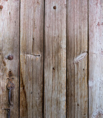 Fragment of old wooden door made with roughly handled planks
