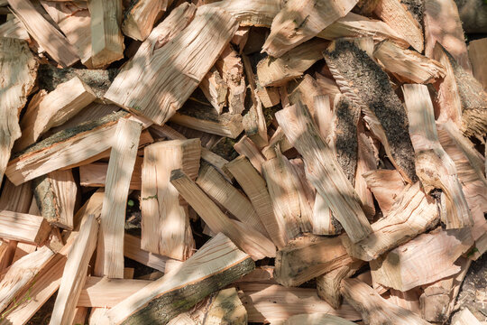 Heap of split firewood, fragment close-up in sunny day