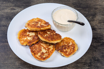 Cottage cheese pancakes with sour cream on the dish