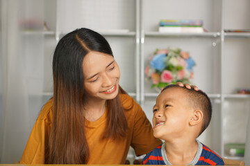 Obraz premium happy mother and son at home desk