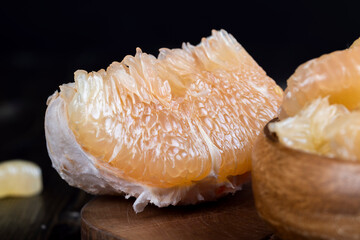 Freshly peeled pink pomelo on the table