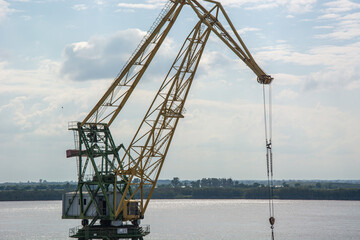 Fototapeta na wymiar Large metal construction crane in the port