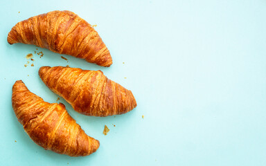 Croissant at blue background. French bakery. Flat lay image with copy space.