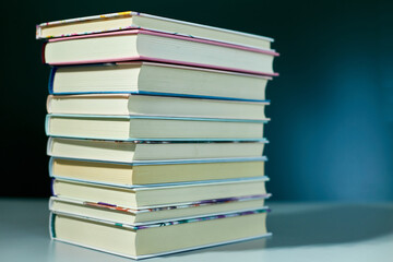Stack of books on dark backgrounds, World book day, knowledge and creativity concept, spring, summer mood, copy space, top view.