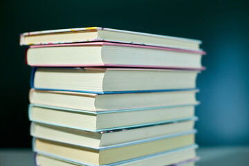 Stack of books on dark backgrounds, World book day, knowledge and creativity concept, spring, summer mood, copy space, top view.