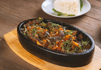 Oriental food, delicious meat sauté in a traditional frying pan.