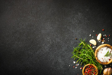 Ingredients for cooking on black stone kitchen table. Herbs, spices and vegetables. Top view with...