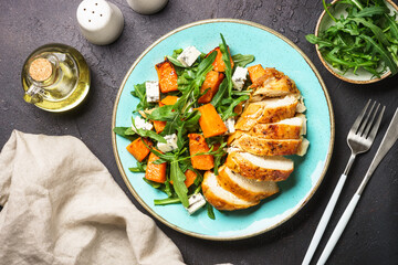 Warm salad with baked chicken breast, pumpkin, blue cheese and arugula. Dash diet, keto diet meal....