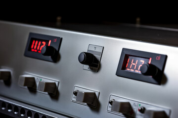Macro shot of an industrial oven control panel with digital temperature readout and buttons for adjusting settings