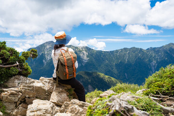 Hiking woman sit on the rock over the peak in east peak of Hehuanshan