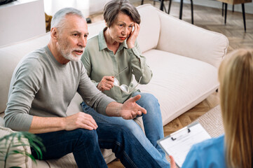 Anxious mature couple listening doctor explaining prescription, test results, diagnosis