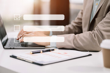 Business performance checklist concept, businessman using tablet and laptop doing online checklist survey, filling out digital form checklist.