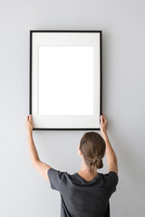 Woman hold blank picture frame mockup on white wall, Artwork mock-up in minimal interior design, Minimal photographer artist concept
