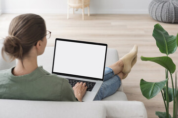 Young woman using laptop computer with blank empty mockup screen. Business woman working at home. Freelance, student lifestyle, e-learning, shopping online, web site, technology concept