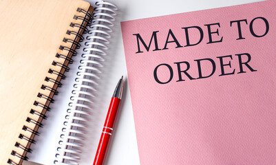 MADE TO ORDER word on the pink paper with office tools on white background