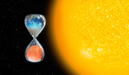 Global warming concept - Planet Earth is becoming a dead planet like Mars - Hourglass inside Planet Earth and Mars isolated on black background "Elements of this image furnished by NASA "