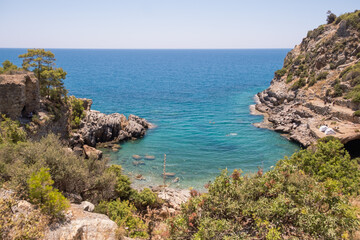 Fototapeta na wymiar View to Mediterranean sea from the coast. Rocky sea coast covered by pines in Alanya, Turkey.