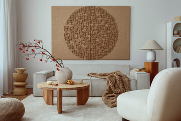 Creative composition of living room interior with mock up poster frame, beige sofa, wooden coffee table, rounded shapes armchair, vase with rowanberry and personal accessories. Home decor. Template..