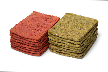 Heap of vegetable crackers seasoned with spinach and beet isolated on white background