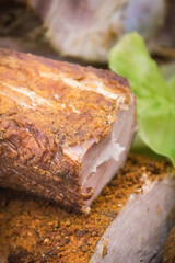 Fresh prepared smoked hams with spices on market stall