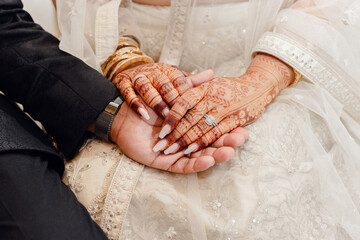 The hands of an Indian bride are decorated with traditional henna designs and designs. The bride...
