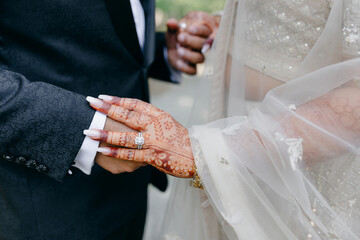 The hands of an Indian bride are decorated with traditional henna designs and designs. The bride...