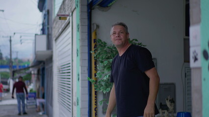 Middle-Aged Man Observing Urban Neighborhood from Street in front of storefront